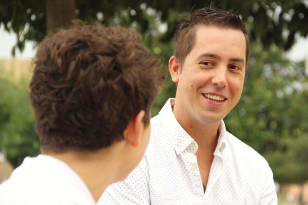 Daniel Escudero sonriendo durante una conversación cercana en un entorno natural