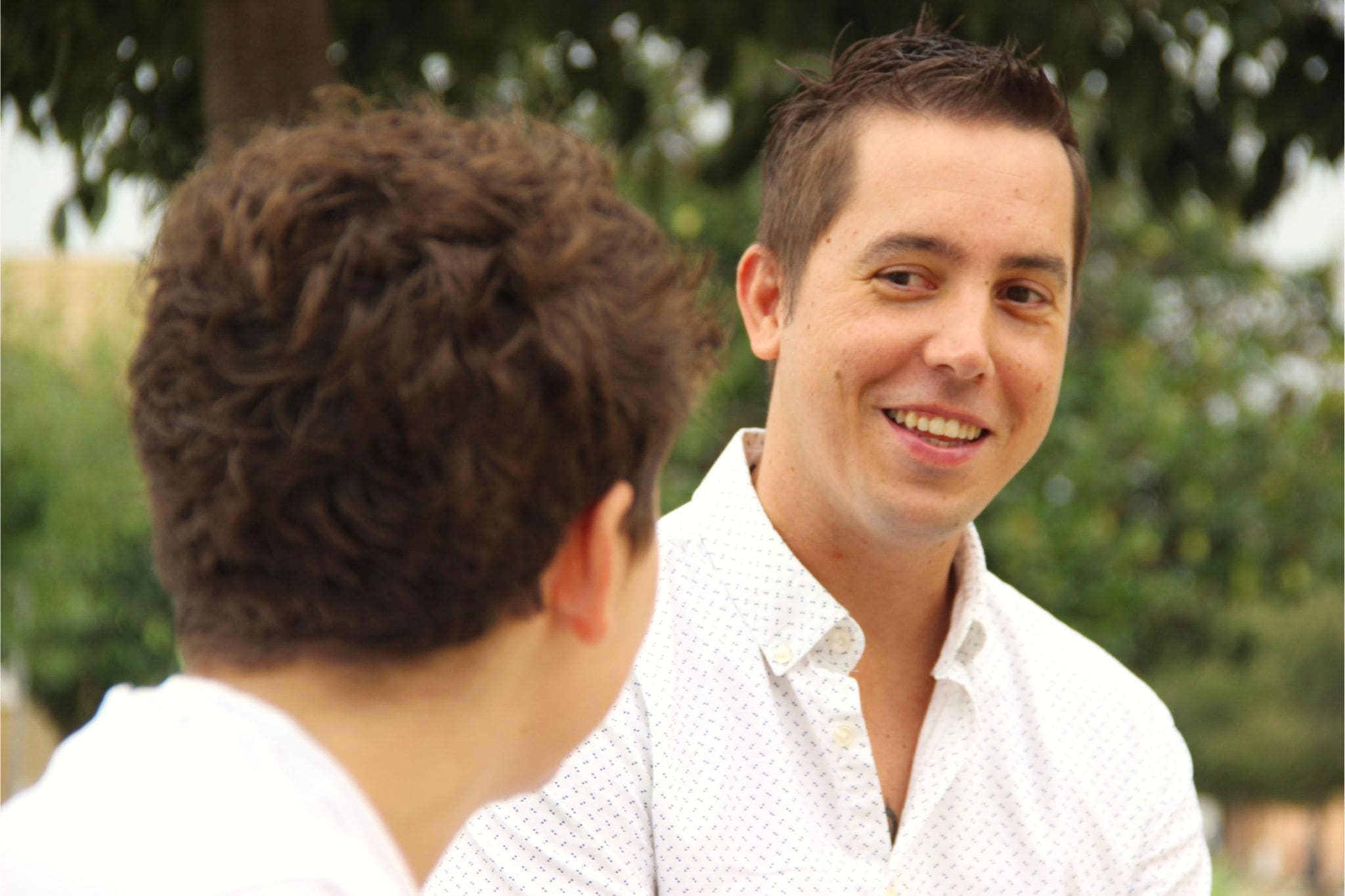 Daniel Escudero sonriendo durante una conversación cercana en un entorno natural