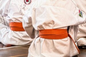 niños con cinturón naranja de artes marciales simbolizando disciplina y esfuerzo
